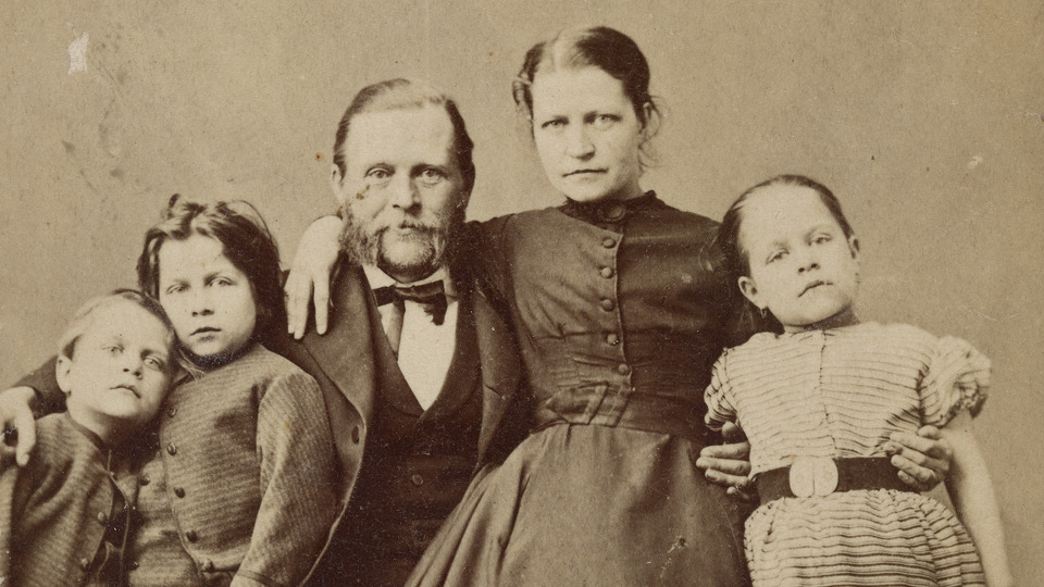 Bilden uttrycker ovanligt mycket intimitet, med kvinnan på mannens knä och med armen om hans hals och barnen nära intill varandra.